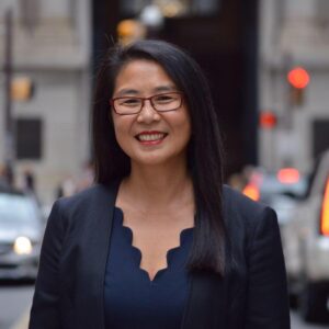 Smiling Asian woman wearing glasses and a jacket